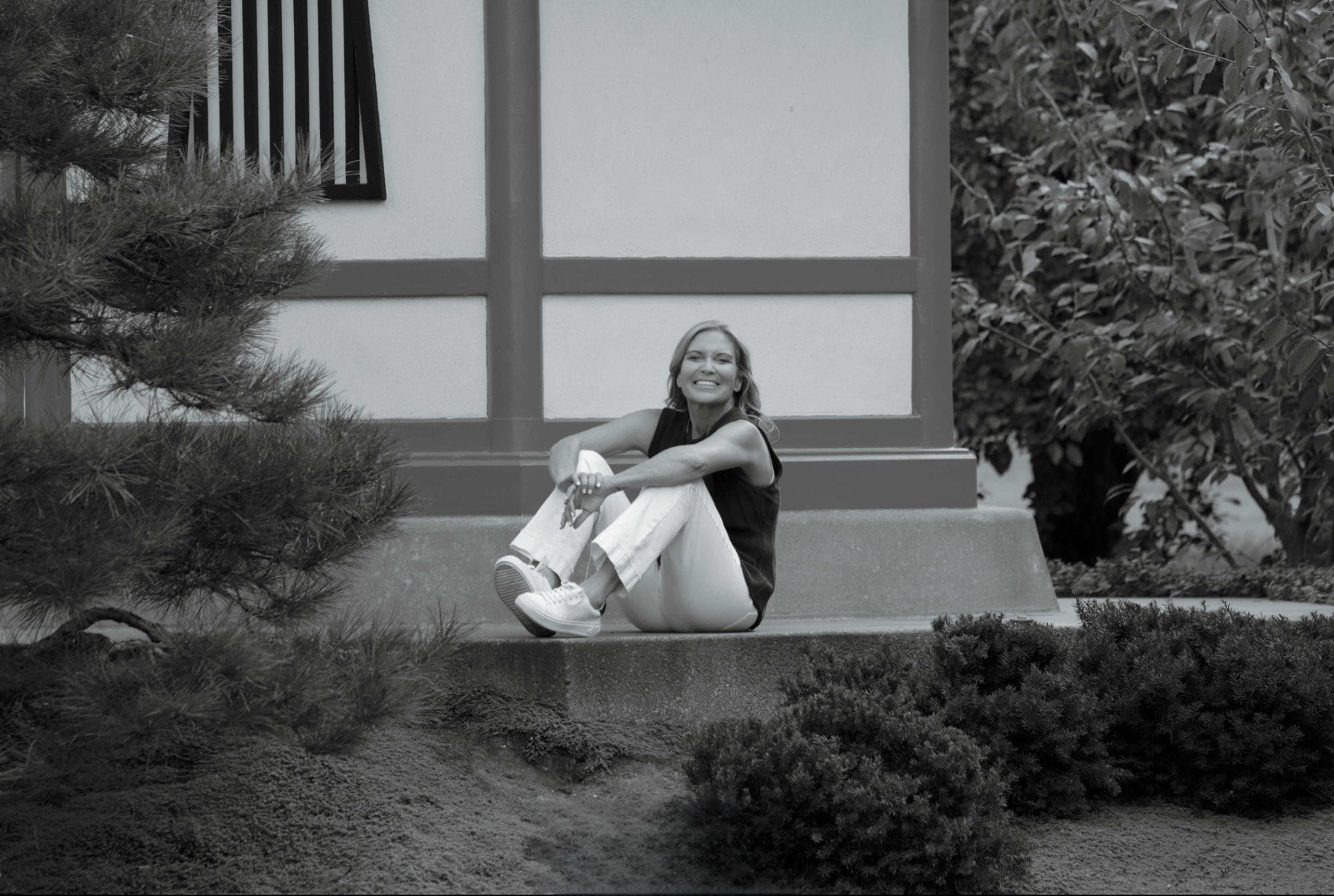 Donna Walker seated on a garden step, black and white